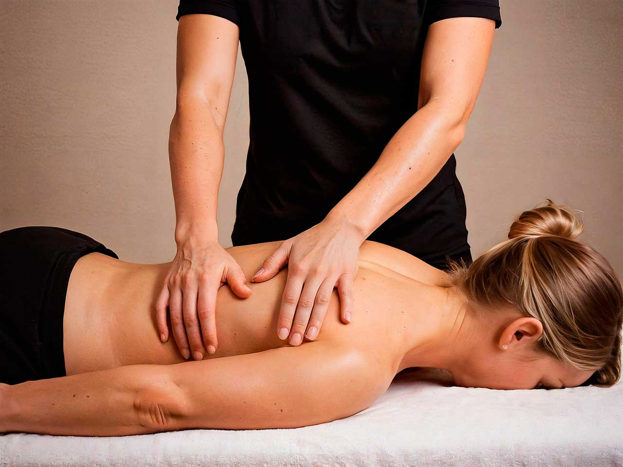 Fisioterapeuta realizando masaje terapéutico en la espalda de una paciente – Fisioterapia Valenzuela